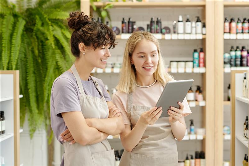 two-young-smiling-shop-assistants-looking-at-table-2023-11-27-04-58-27-utc (1)
