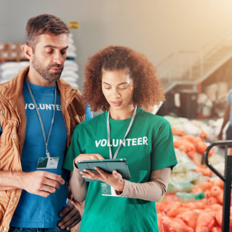 Warehouse, charity and people with tablet, help and review of donations on website and discussion. .