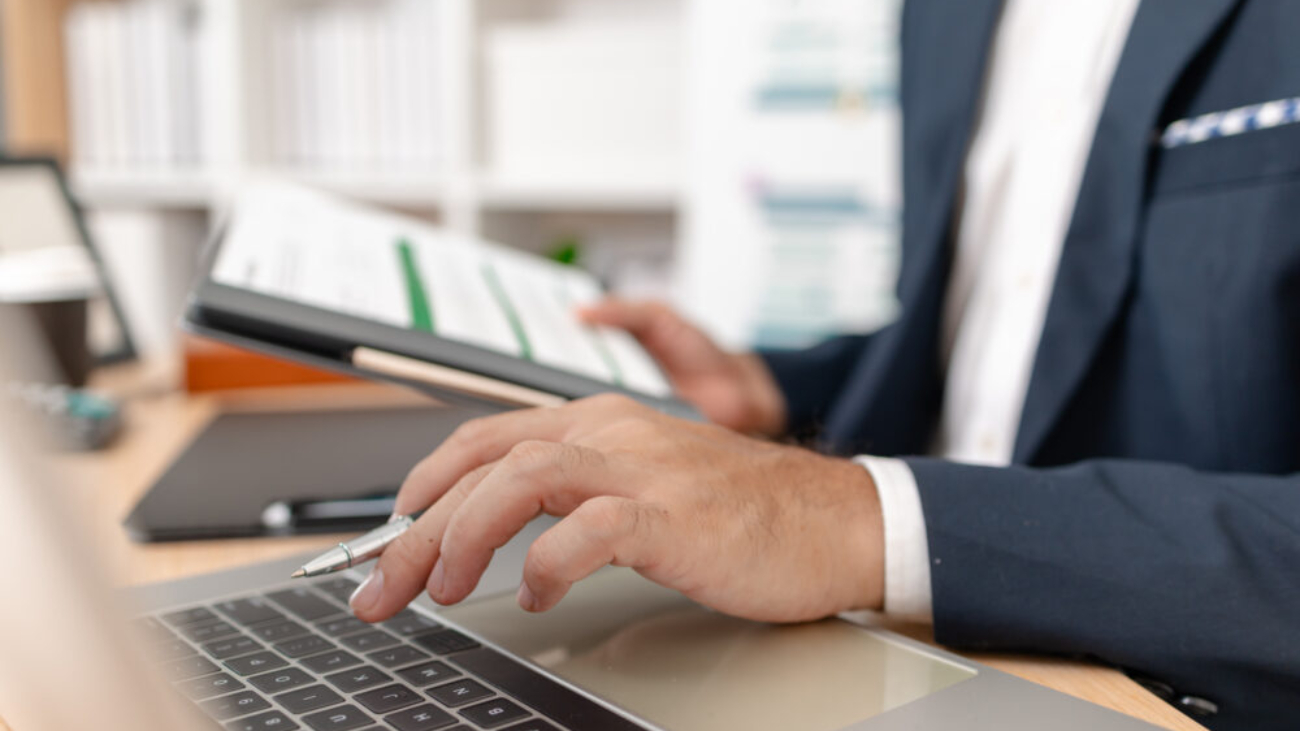 A businessman in a suit analysing financial charts using Sage accounting software