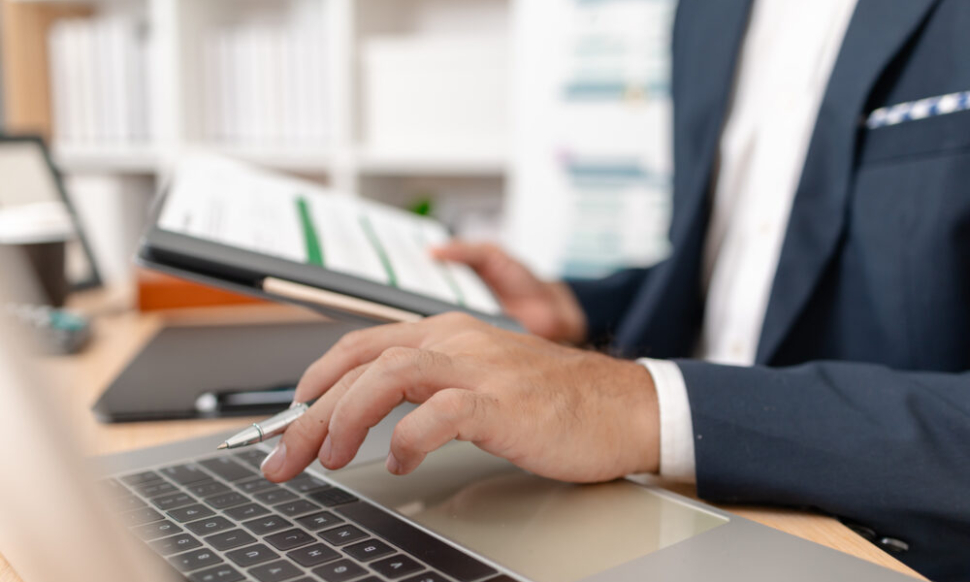 A businessman in a suit analysing financial charts using Sage accounting software