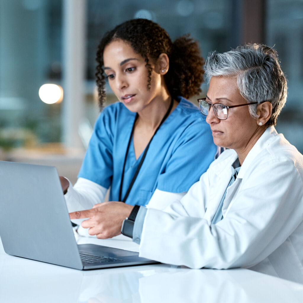 Healthcare finance team using Sage Intacct on a laptop in a clinical setting