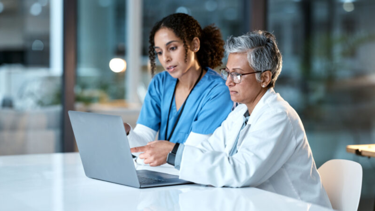 Healthcare finance team using Sage Intacct on a laptop in a clinical setting
