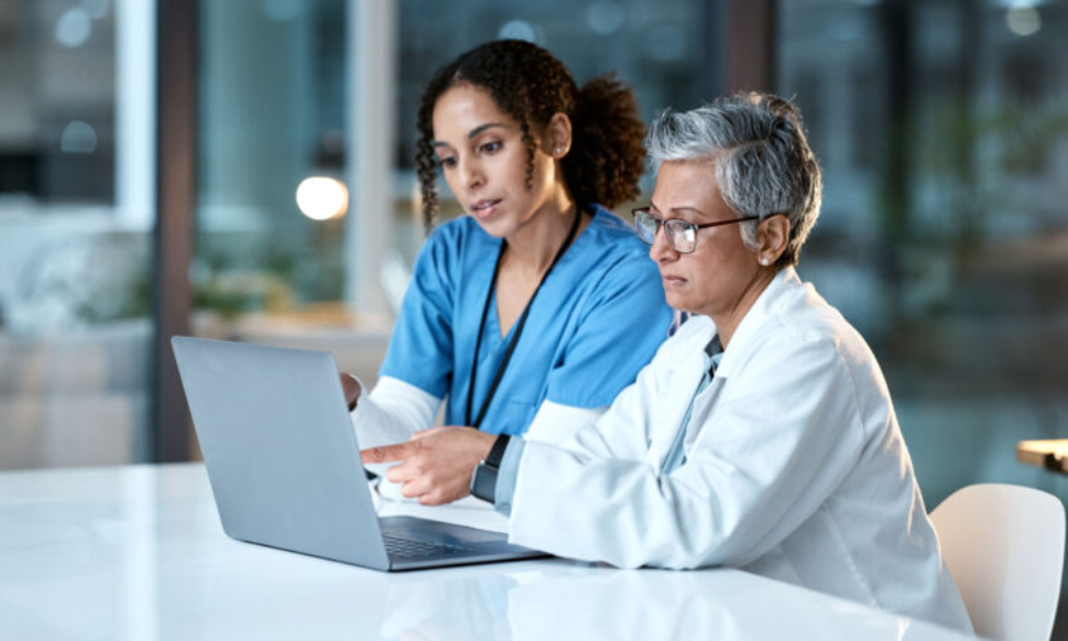 Healthcare finance team using Sage Intacct on a laptop in a clinical setting