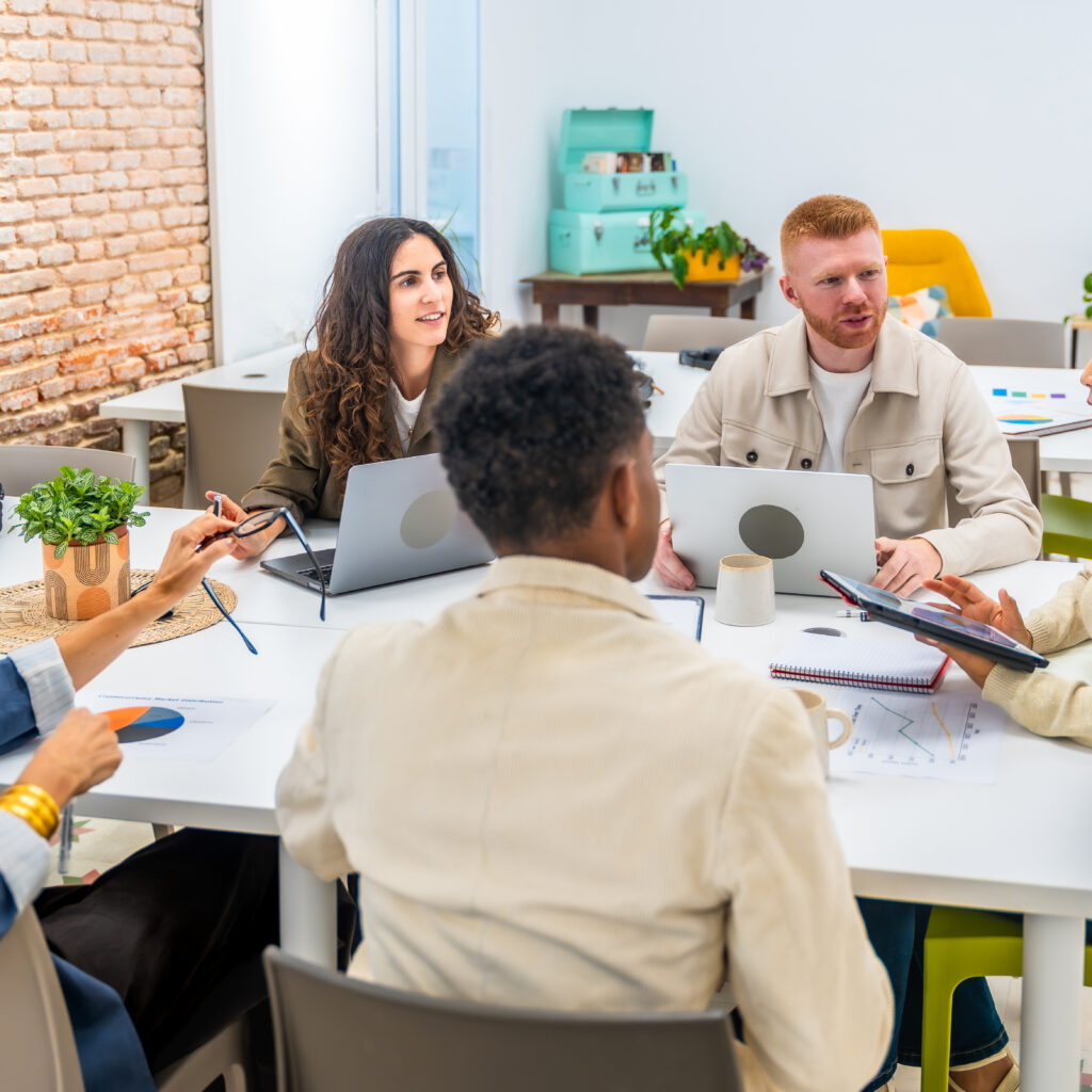 Diverse startup team collaborating in office using Sage Ireland charity accounting software dashboards