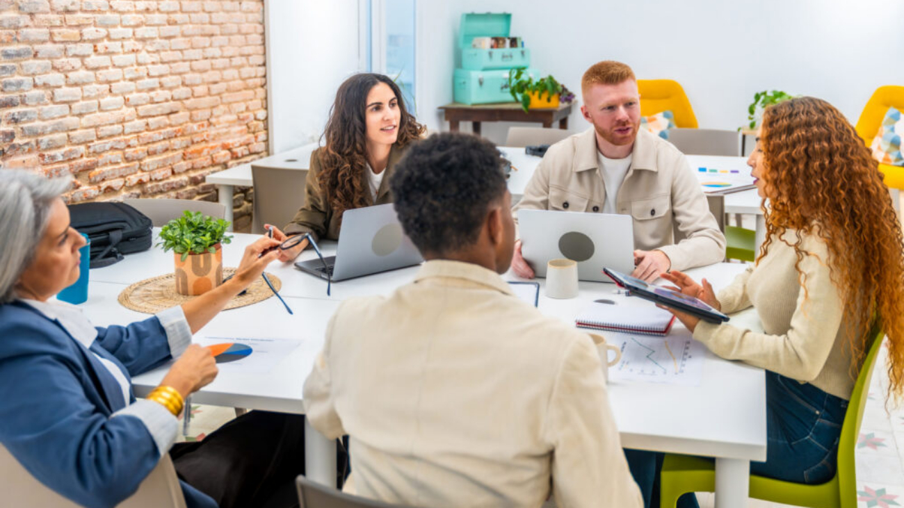 Diverse startup team collaborating in office using Sage Ireland charity accounting software dashboards