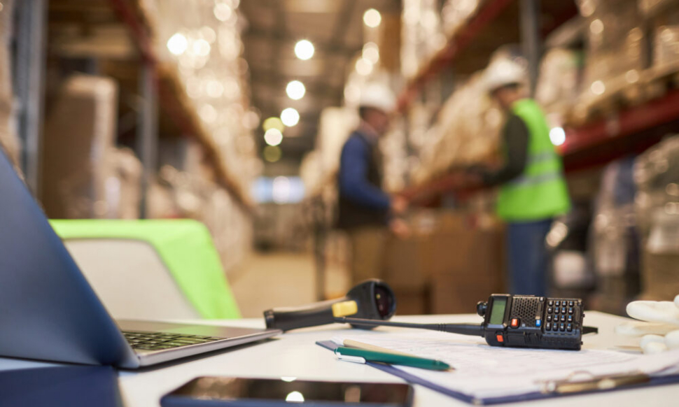 Sage warehouse desk setup with stock control documents and inventory system tools