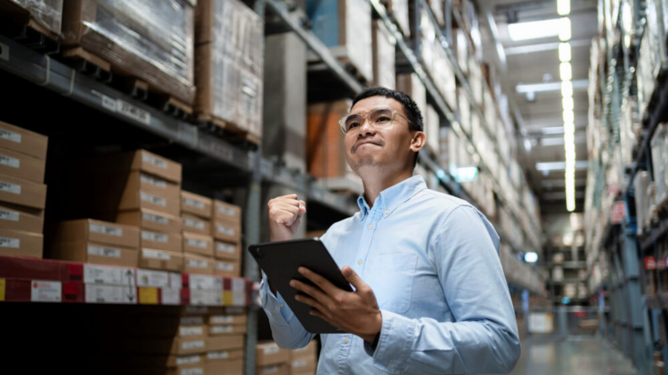 Business professional in a warehouse using Sage 200 and Sage accounting software to monitor stock and business performance in Ireland.