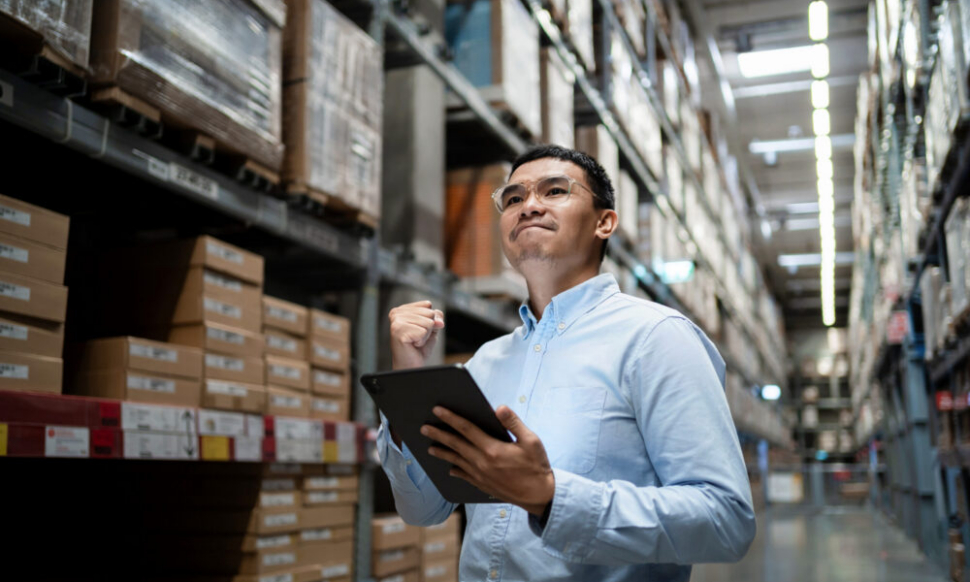 Business professional in a warehouse using Sage 200 and Sage accounting software to monitor stock and business performance in Ireland.